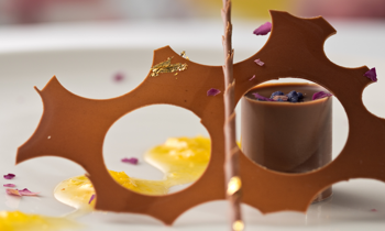 Dezert ChocoTube Passion s ovocným dipom s marakuje. Dekorácia: tenký plátok čokolády s čokoládovou špirálou a sušené okvetné lupienky ruže.