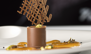 Dezert ChocoTube Salt Caramel s karamelovým dipom a pistáciami. Dekorácia: čokoládová mriežka.